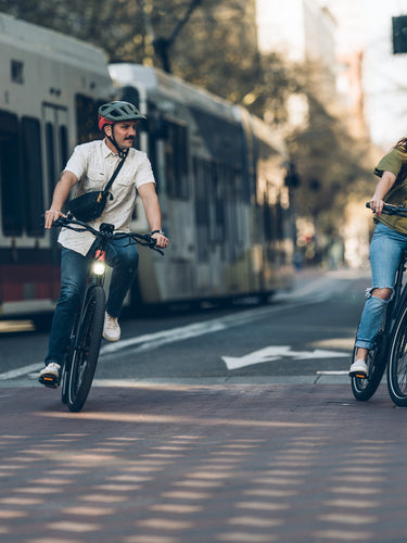 couple riding alpha ebikes through downtown portland